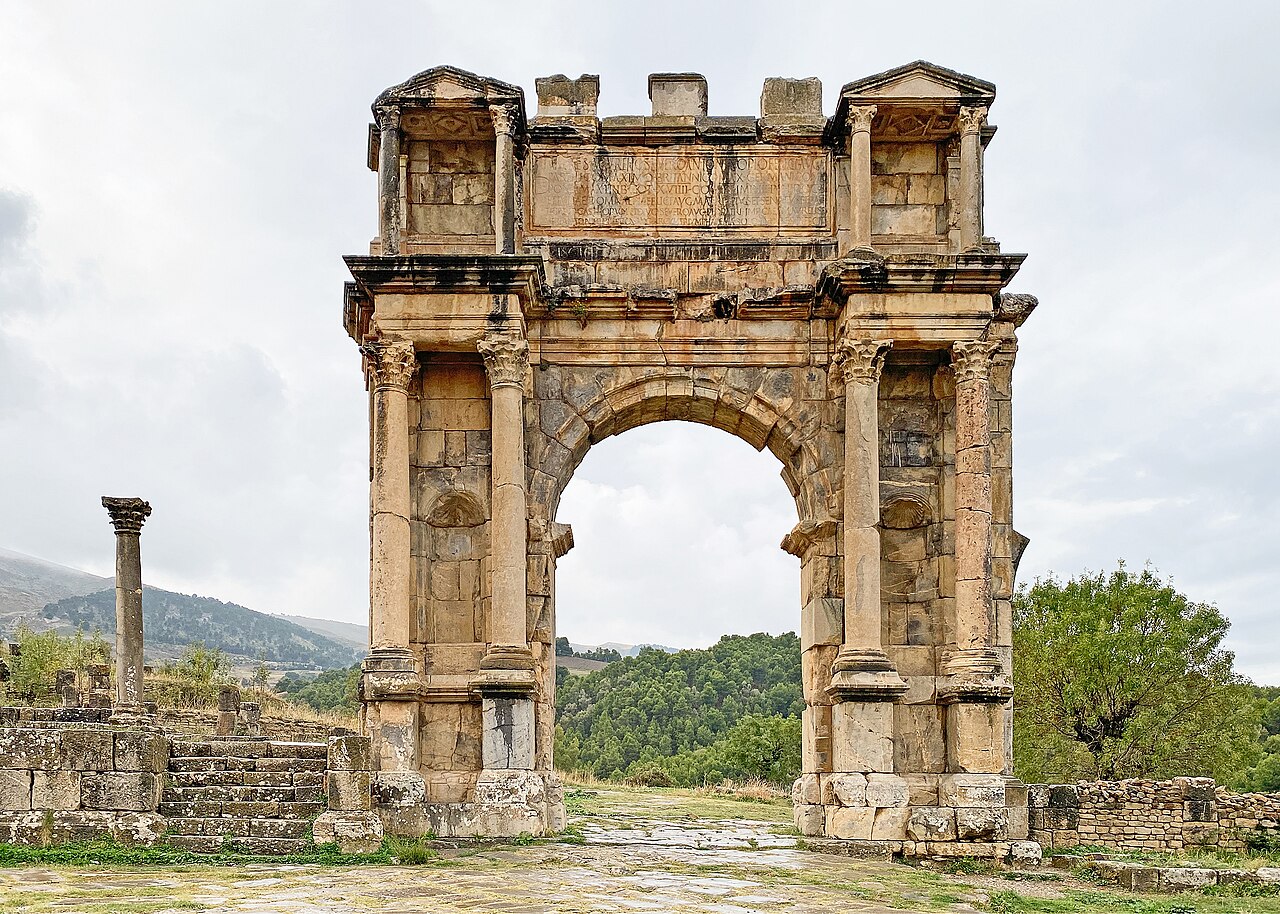 L’arc de Caracalla à Djémila, arche romaine debout au milieu du site, collines vertes en arrière-plan
